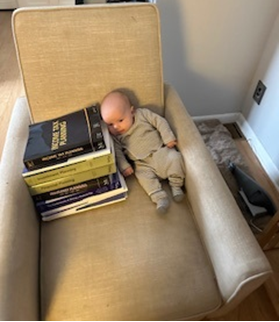 A baby lying on a chair with books

AI-generated content may be incorrect.