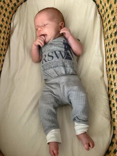 A baby lying in a crib

Description automatically generated